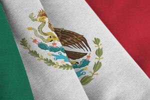 Mexico flag with big folds waving close up under the studio light indoors. The official symbols and colors in banner photo