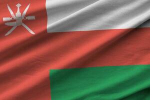 Oman flag with big folds waving close up under the studio light indoors. The official symbols and colors in banner photo