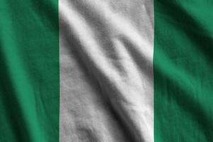 Nigeria flag with big folds waving close up under the studio light indoors. The official symbols and colors in banner photo