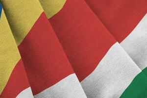 Seychelles flag with big folds waving close up under the studio light indoors. The official symbols and colors in banner photo
