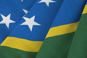 Solomon Islands flag with big folds waving close up under the studio light indoors. The official symbols and colors in banner photo