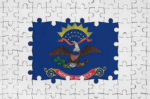 North Dakota US state flag in frame of white puzzle pieces with missing central part photo