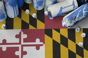 Maryland US state flag and few used aerosol spray cans for graffiti painting. Street art culture concept photo