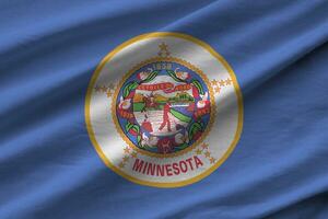 Minnesota US state flag with big folds waving close up under the studio light indoors. The official symbols and colors in banner photo