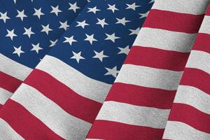 United States of America flag with big folds waving close up under the studio light indoors. The official symbols and colors in banner photo