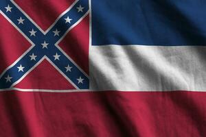 mississippi nueva bandera del estado de estados unidos con grandes pliegues ondeando de cerca bajo la luz del estudio en el interior. los símbolos y colores oficiales en banner foto