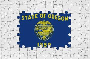 Oregon US state flag in frame of white puzzle pieces with missing central part photo