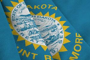 South Dakota US state flag with big folds waving close up under the studio light indoors. The official symbols and colors in banner photo