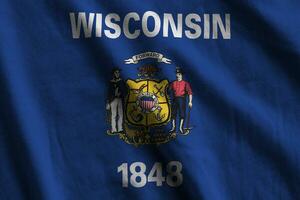 Wisconsin US state flag with big folds waving close up under the studio light indoors. The official symbols and colors in banner photo