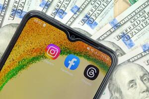 KYIV, UKRAINE - JULY 7, 2023 Threads by Meta application on display of Samsung smartphone and many dollar bills photo