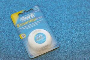 KYIV, UKRAINE - JULY 7, 2023 Oral-B Essentail Floss. Waxed dental floss in round case photo