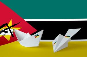 Mozambique flag depicted on paper origami airplane and boat. Handmade arts concept photo