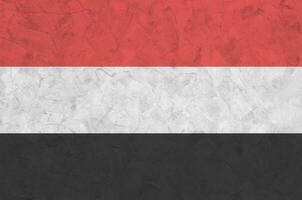 Yemen bandera representado en brillante pintar colores en antiguo alivio enlucido pared. texturizado bandera en áspero antecedentes foto