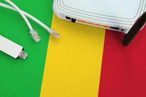 Mali flag depicted on table with internet rj45 cable, wireless usb wifi adapter and router. Internet connection concept photo