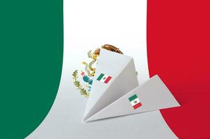 Mexico flag depicted on paper origami airplane. Handmade arts concept photo