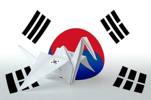 South Korea flag depicted on paper origami crane wing. Handmade arts concept photo