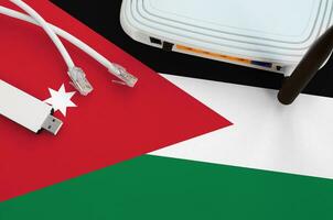 Jordan flag depicted on table with internet rj45 cable, wireless usb wifi adapter and router. Internet connection concept photo