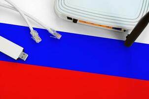 Russia flag depicted on table with internet rj45 cable, wireless usb wifi adapter and router. Internet connection concept photo
