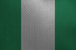 Nigeria flag depicted in paint colors on old brushed metal plate or wall closeup. Textured banner on rough background photo