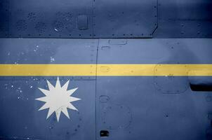 Nauru flag depicted on side part of military armored helicopter closeup. Army forces aircraft conceptual background photo