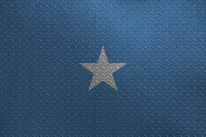 Somalia flag depicted in paint colors on old brushed metal plate or wall closeup. Textured banner on rough background photo