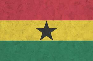 Ghana flag depicted in bright paint colors on old relief plastering wall. Textured banner on rough background photo