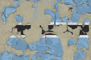 Botswana flag depicted in paint colors on old obsolete messy concrete wall closeup. Textured banner on rough background photo