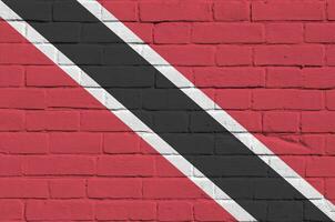 Trinidad and Tobago flag depicted in paint colors on old brick wall. Textured banner on big brick wall masonry background photo