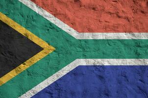 South Africa flag depicted in bright paint colors on old relief plastering wall. Textured banner on rough background photo