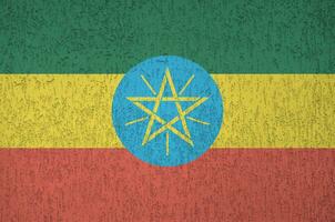 Ethiopia flag depicted in bright paint colors on old relief plastering wall. Textured banner on rough background photo