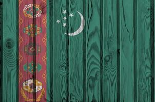 Turkmenistan flag depicted in bright paint colors on old wooden wall. Textured banner on rough background photo