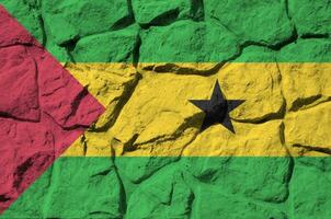 Sao Tome and Principe flag depicted in paint colors on old stone wall closeup. Textured banner on rock wall background photo