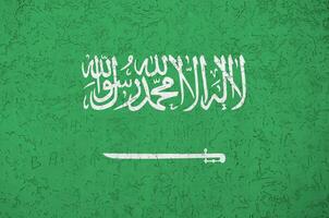 saudi arabia bandera representado en brillante pintar colores en antiguo alivio enlucido pared. texturizado bandera en áspero antecedentes foto