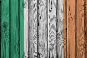 Ireland flag depicted in bright paint colors on old wooden wall. Textured banner on rough background photo