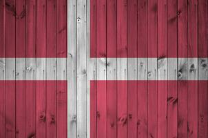 Denmark flag depicted in bright paint colors on old wooden wall. Textured banner on rough background photo