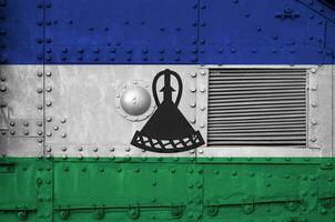 Lesotho flag depicted on side part of military armored tank closeup. Army forces conceptual background photo
