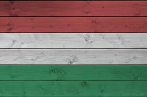 Hungary flag depicted in bright paint colors on old wooden wall. Textured banner on rough background photo