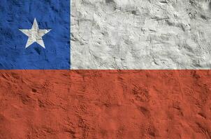 Chile flag depicted in bright paint colors on old relief plastering wall. Textured banner on rough background photo