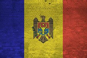 Moldova flag depicted in paint colors on old brick wall. Textured banner on big brick wall masonry background photo