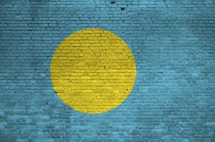 Palau flag depicted in paint colors on old brick wall. Textured banner on big brick wall masonry background photo