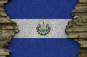 El Salvador flag depicted in paint colors on old stone wall closeup. Textured banner on rock wall background photo