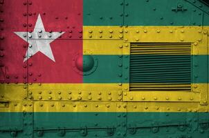 Togo flag depicted on side part of military armored tank closeup. Army forces conceptual background photo