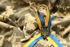 Military camouflage fabric with ukrainian stripes on ribbon photo