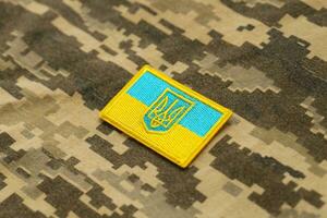 Military camouflage fabric with ukrainian flag on uniform chevron photo