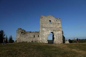 TERNOPIL, UKRAINE - SEPTEMBER 16, 2023 Scenic view of ruins of an ancient Kremenets castle. Ternopil region, Ukraine. Gate tower and part of defensive wall on Bona mountain photo