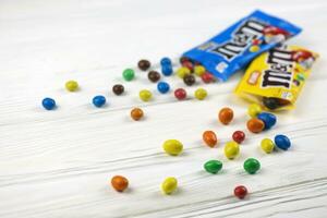 KHARKIV, UKRAINE - JANUARY 2, 2021 M and Ms colorful button shaped chocolate candies. Multi colored chocolates each of which has the letter m printed in lower case in white photo