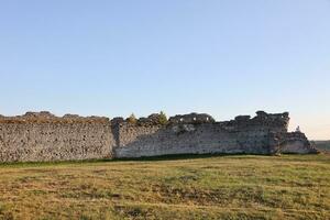 TERNOPIL, UKRAINE - SEPTEMBER 16, 2023 Scenic view of ruins of an ancient Kremenets castle. Ternopil region, Ukraine. Gate tower and part of defensive wall on Bona mountain photo