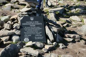 CARPATHIAN MOUNTAINS, UKRAINE - OCTOBER 8, 2022 Ukrainian monument at peak of Hoverla mountain in Carpathians photo