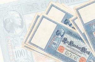 100 Reich marks bills lies in stack on background of big semi-transparent banknote. Abstract presentation of national currency photo