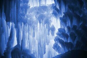 Huge ice icicles. Large blocks of ice frozen water. Blue ice background. Frozen stream waterfall. phantom classic blue color photo